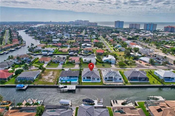 Waterfront property featuring a private boat dock, backyard swimming pool, and a white exterior