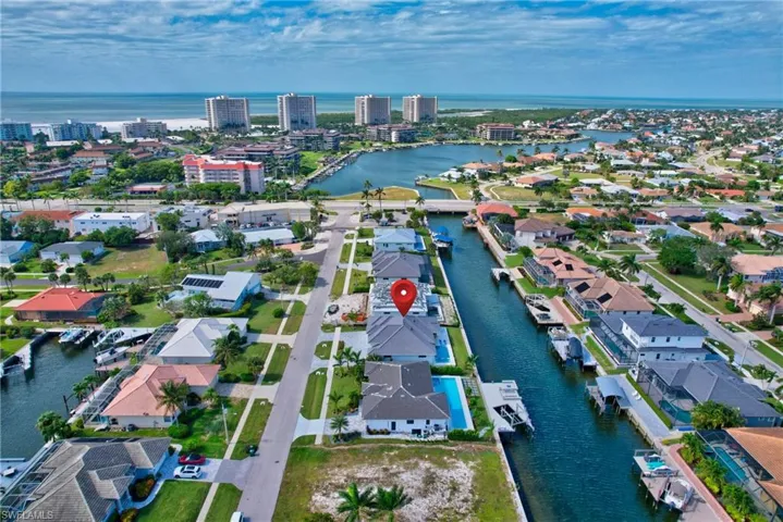 Waterfront property featuring a private boat dock, a private swimming pool, and a paved driveway