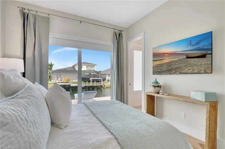 Room featuring a full-wall sliding glass door, canal access, a private dock, and light-toned walls