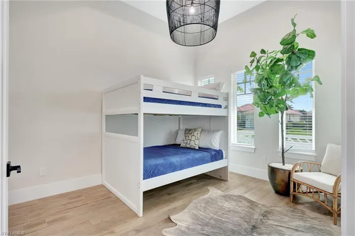 Interior room featuring light-toned walls, wood-finish flooring, and white baseboards