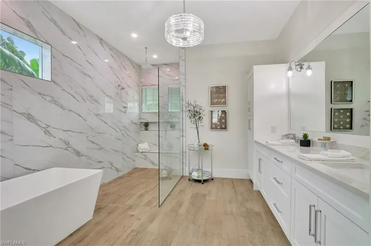 Spacious bathroom featuring wood-finish flooring and a freestanding soaking tub