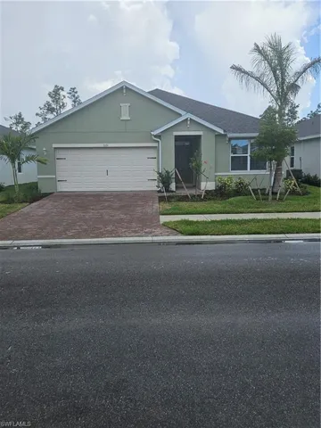 Single story home with decorative driveway, stucco siding, and an attached garage