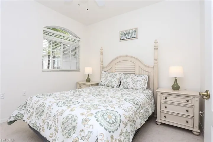 Carpeted bedroom featuring a ceiling fan