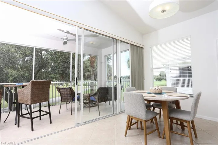 Sunroom featuring lofted ceiling, a ceiling fan, and outdoor dining area