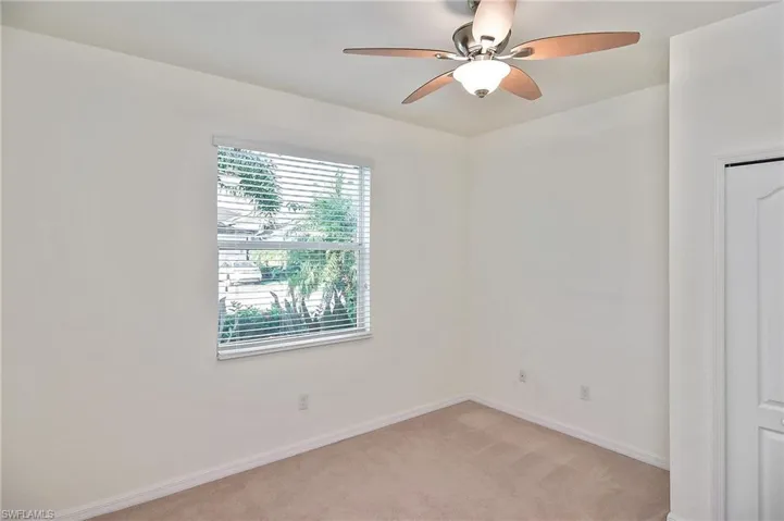 Carpeted spare room with ceiling fan