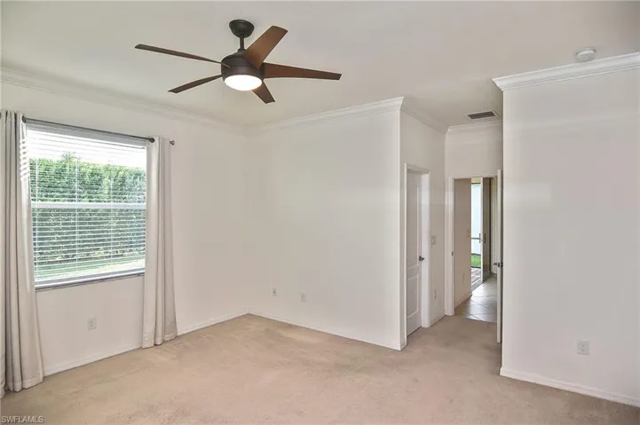 Spare room with crown molding, ceiling fan, and light colored carpet