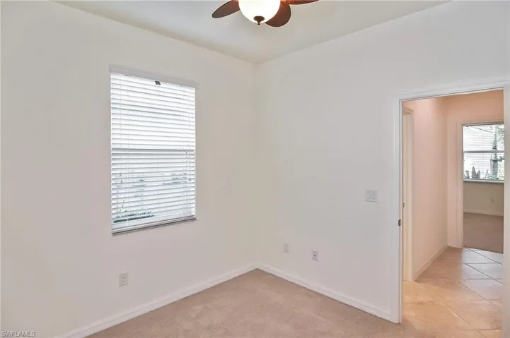 Unfurnished room with ceiling fan and light tile floors