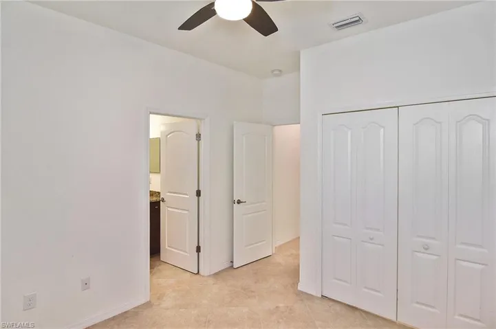 Unfurnished bedroom with a closet, ceiling fan, and light tile floors