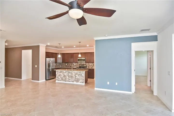 Kitchen with tasteful backsplash, ceiling fan, appliances with stainless steel finishes, light tile floors, and pendant lighting