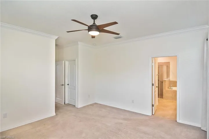 Carpeted spare room with ornamental molding and ceiling fan