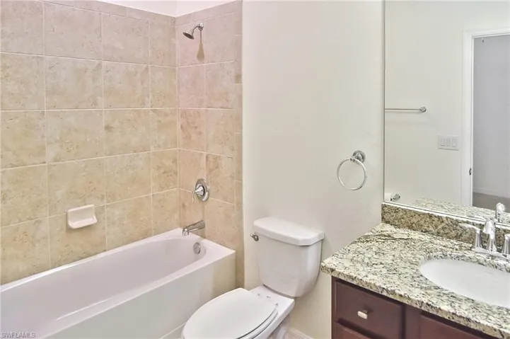 Full bathroom with vanity, toilet, and tiled shower / bath combo