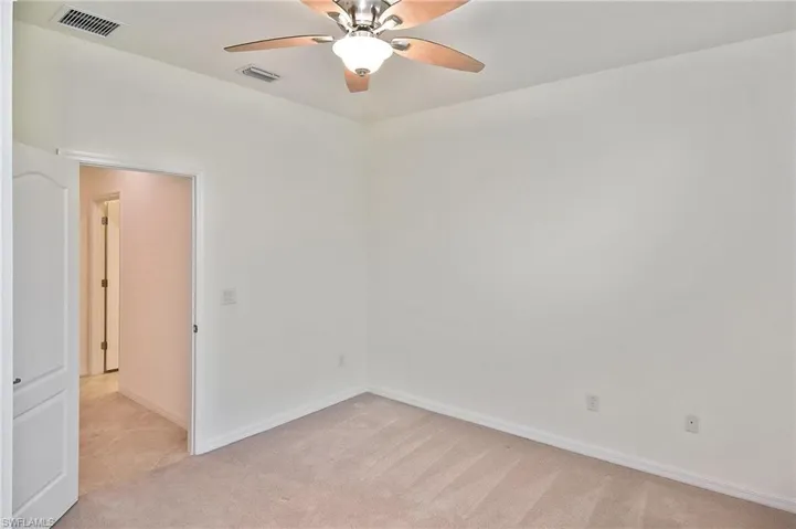 Carpeted spare room with ceiling fan