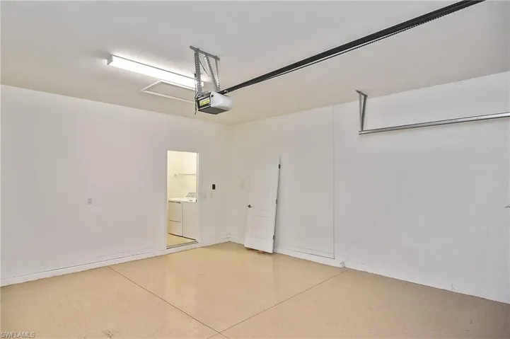 Garage featuring washing machine and dryer and a garage door opener