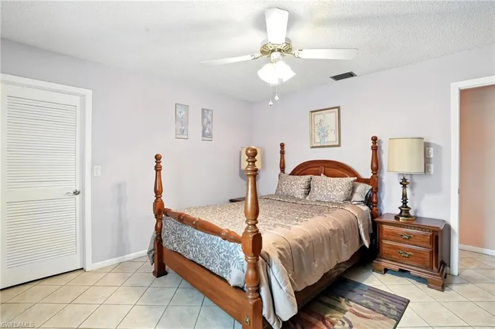 Bedroom featuring light tile patterned floors, a textured ceiling, and ceiling fan