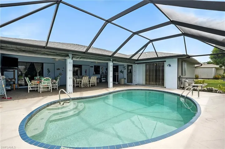 Outdoor pool featuring a sunroom, a patio area, a ceiling fan, and glass enclosure