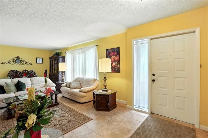 Living room featuring a textured ceiling and light tile patterned flooring