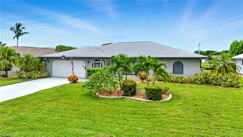 Single story home featuring stucco siding, driveway, a front yard, and an attached garage