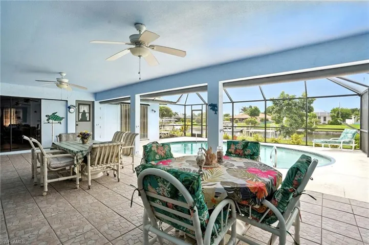 View of patio featuring outdoor dining space, a sunroom, an outdoor pool, a lanai, and a water view