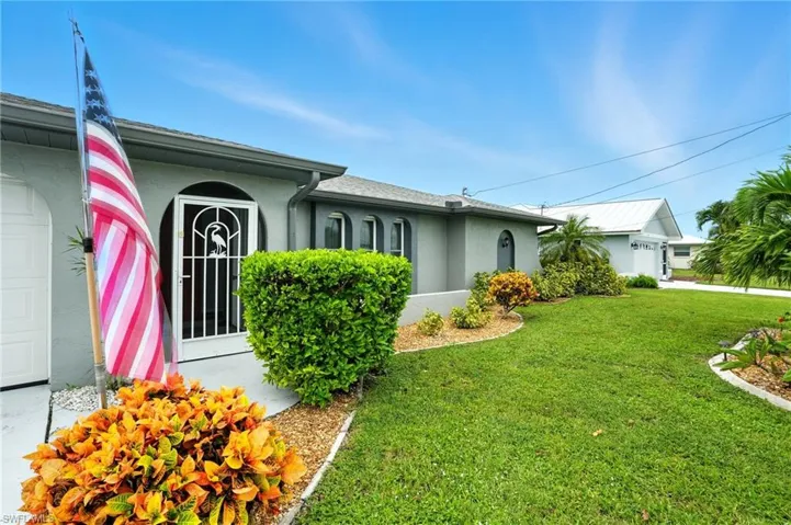 View of property exterior with stucco siding and a lawn