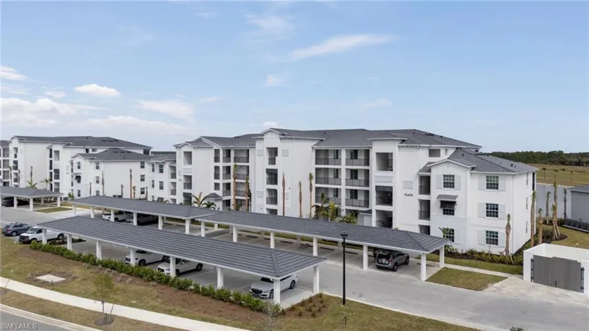 View of apartment building / complex with covered parking