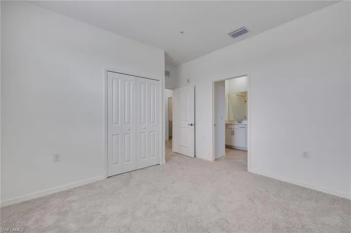 Unfurnished bedroom with light carpet and a closet