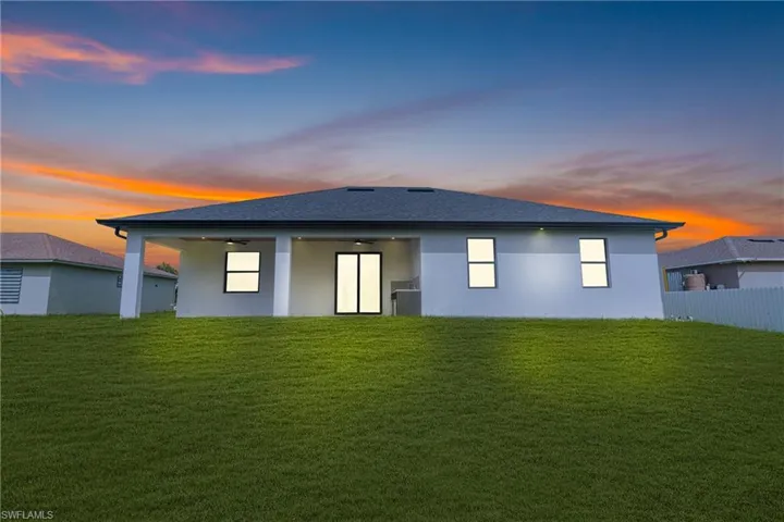 Back of property with a yard, a patio area, and stucco siding