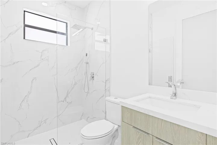 Full bathroom featuring vanity and a marble finish shower