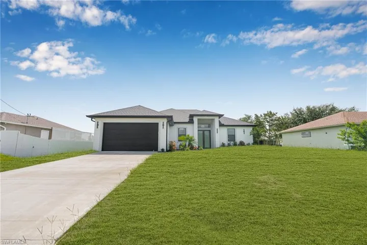 Prairie-style house featuring driveway, an attached garage, and stucco siding
