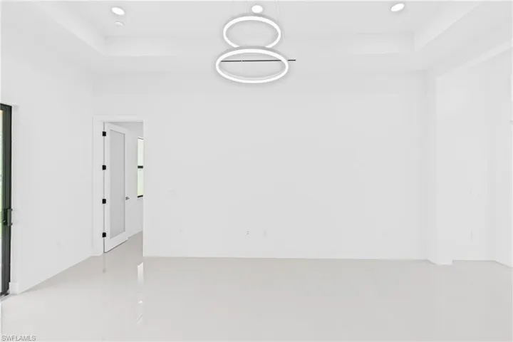 Unfurnished room featuring a tray ceiling and recessed lighting