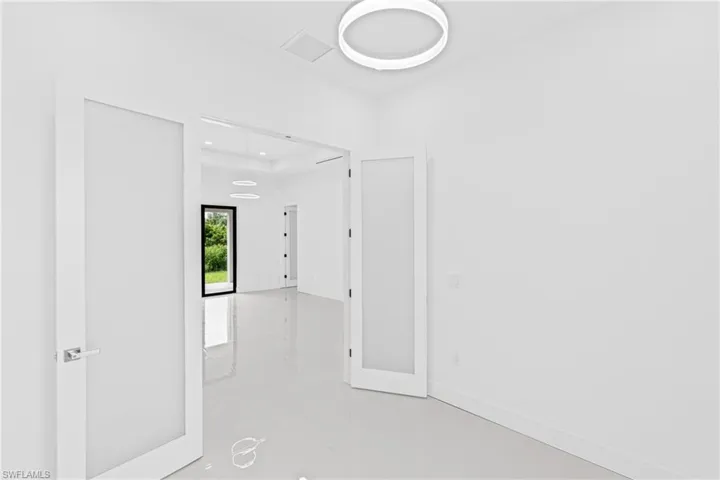 Empty room with finished concrete flooring and baseboards