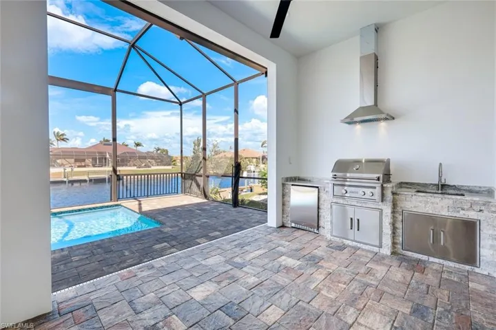 Complete outdoor kitchen, featuring grill, fridge and sink