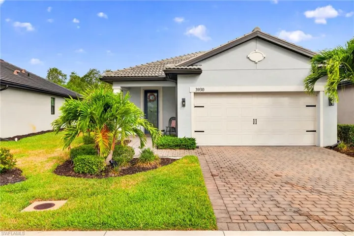 Contemporary single-story residence featuring a decorative gable vent, light gray exterior siding, and a tiled roof