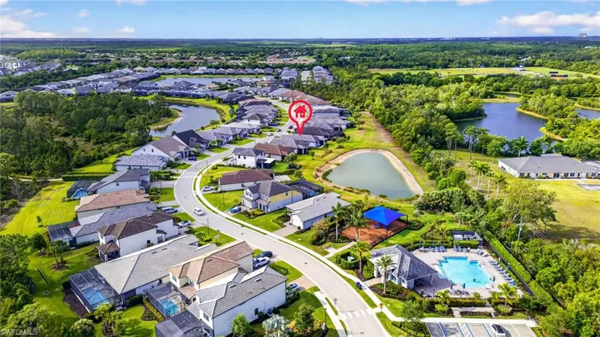 Aerial view of a residential community featuring a curved street layout, multiple retention ponds, and established landscaping