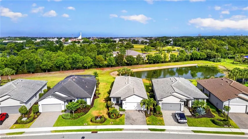 Modern single-story home with a two-car garage, gray tile roof, and a paver driveway