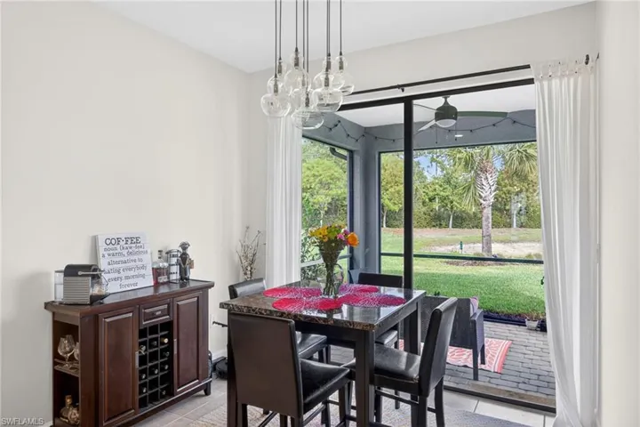 Dining area featuring a contemporary multi-globe pendant light fixture and a sliding glass door opening to a screened patio