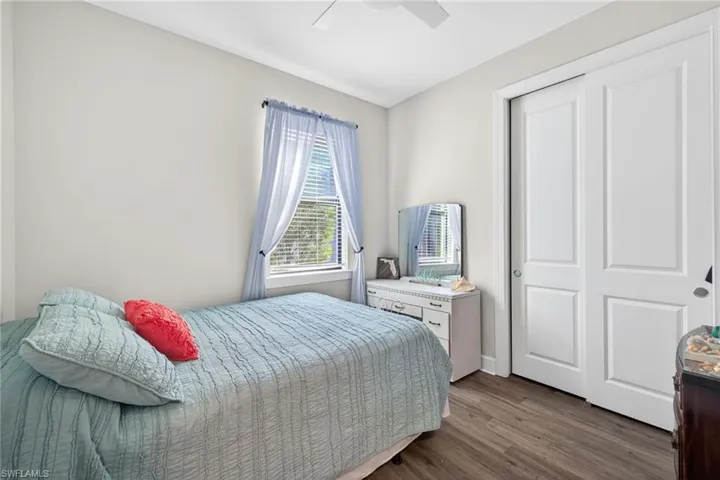 Light-filled room featuring wood-finish flooring, a ceiling fan, and a window with blinds