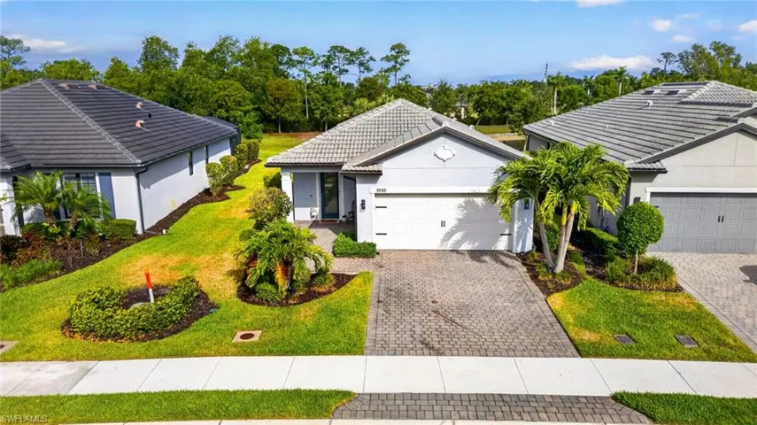 Contemporary single-story residence featuring a tiled roof and light-colored exterior