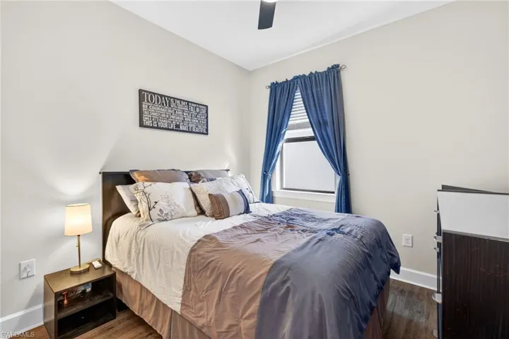 Bedroom featuring wood-finish flooring, a ceiling fan, and a window with blinds