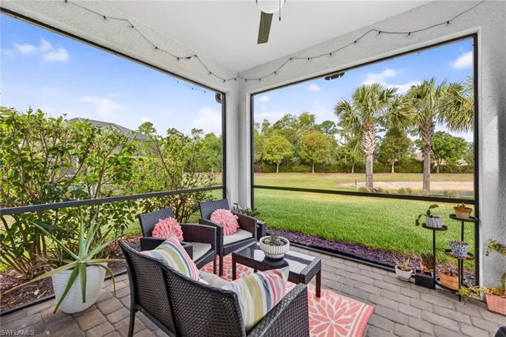 Screened patio featuring a ceiling fan, string lighting, and paver flooring