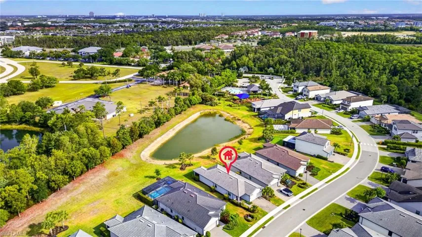 Aerial perspective showcasing a residential community with numerous single-story homes, many featuring private screened pools