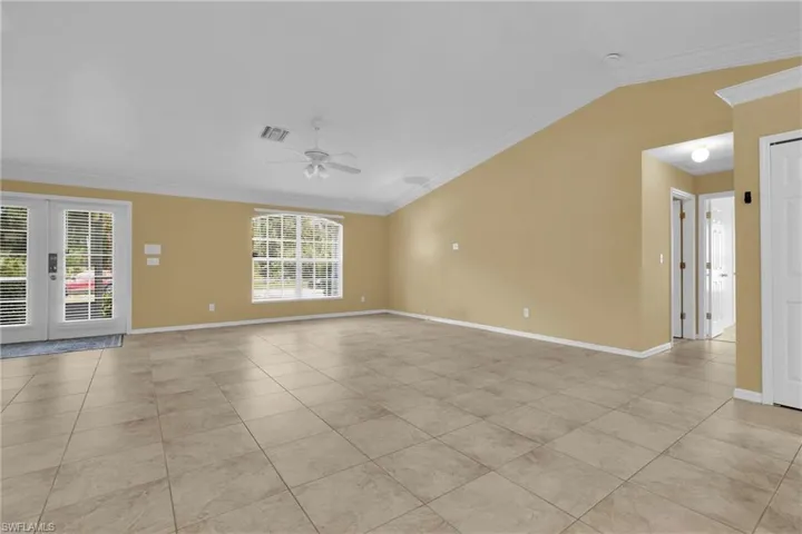 Spacious interior featuring tile flooring, vaulted ceilings, and a ceiling fan