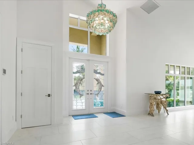Entrance foyer with a high ceiling, plenty of natural light, french doors, and visible vents