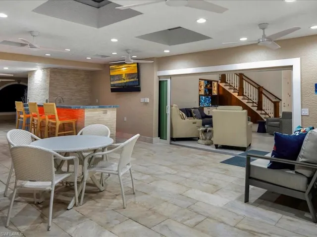 Dining room featuring stairway, a ceiling fan, recessed lighting, bar area, and a textured wall