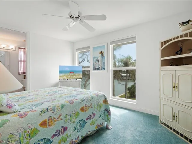 Carpeted bedroom featuring a ceiling fan