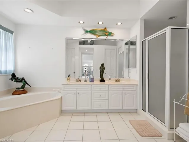Full bath with tile patterned flooring, a garden tub, a stall shower, and a sink