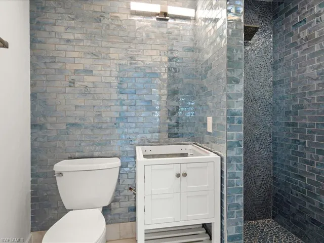 Full bathroom featuring vanity, toilet, and tiled shower