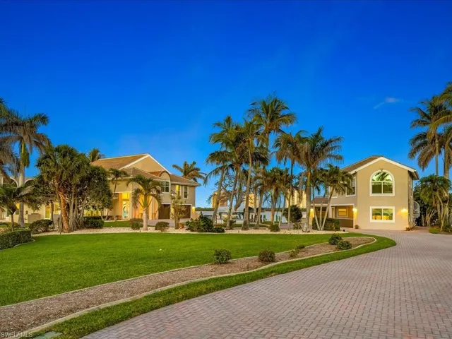 View of property's community with a yard and decorative driveway