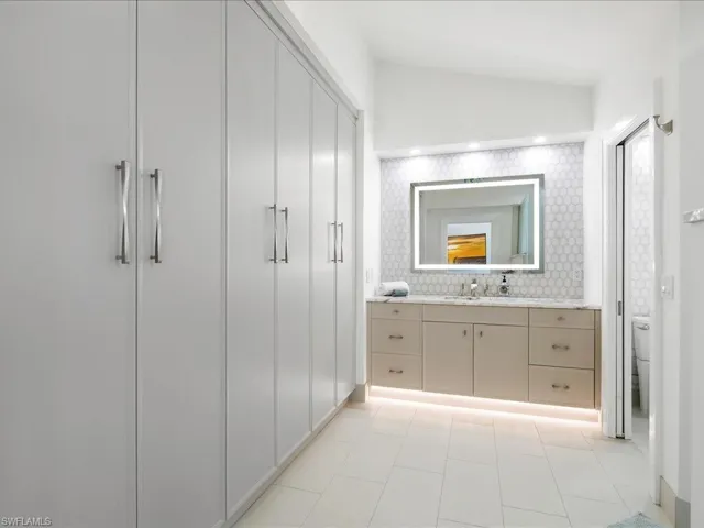 Bathroom featuring lofted ceiling, toilet, and vanity