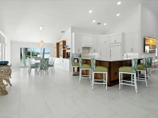 Kitchen featuring custom exhaust hood, a peninsula, tasteful backsplash, and paneled fridge