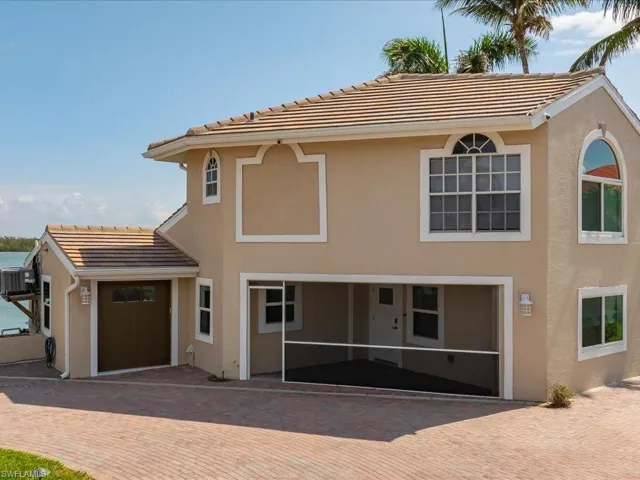 View of front of home with stucco siding, central AC, and a tiled roof